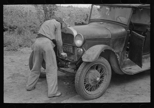 Migrant boy getting ready to crank his car, Muskogee, Oklahoma