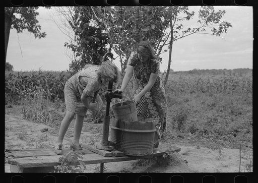 Pumping water near Muskogee, Oklahoma. Daughters of farmer about to migrate to California