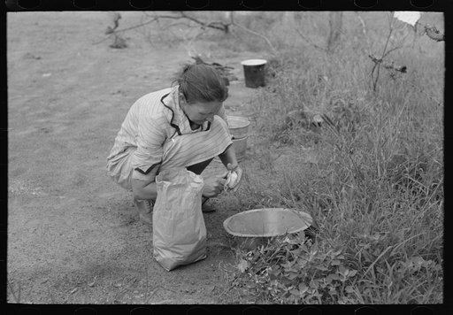 Woman of migrant family peeling potatoes near Henrietta [i.e., Henryetta,] Oklahoma