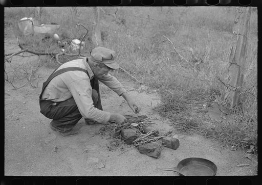 Getting ready to start a fire. Father of migrant family along roadside near Henrietta [i.e., Henryetta,] Oklahoma