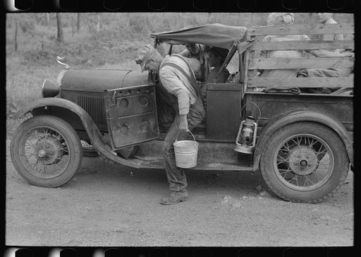 Untitled photo, possibly related to: Migrant getting out of car with pail to get some water. Encamped along roadside near Henrietta [i.e., Henryetta,] Oklahoma
