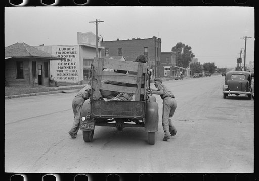 Pushing a truck of migrant family en route to California in order to get it started, near Henrietta [i.e., Henryetta,] Oklahoma