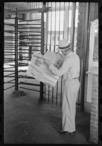 Untitled photo, possibly related to: Man reading newspaper while waiting for streetcar. Streetcar station, Oklahoma City, Oklahoma