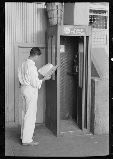Man looking up telephone number. Streetcar terminal, Oklahoma City, Oklahoma