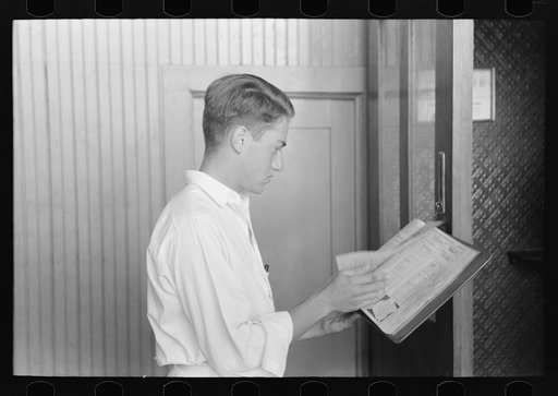 Man looking up telephone number. Streetcar terminal, Oklahoma City, Oklahoma