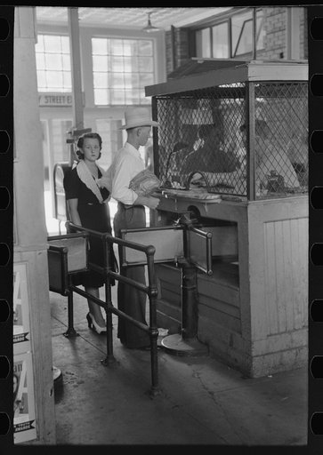 Young couple buying tickets at entrance turnstile. Streetcar terminal, Oklahoma City, Oklahoma