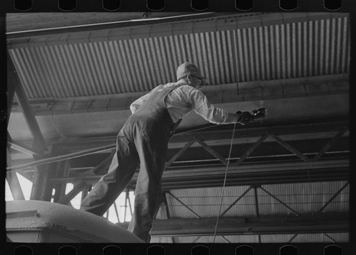 Worker replacing wheel in end of streetcar. Terminal, Oklahoma City, Oklahoma