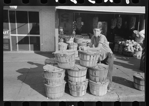 Grocery boy leaning on basket of peaches, Muskogee, Oklahoma