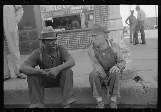 Negro and white man sitting on curb talking, Muskogee, Oklahoma