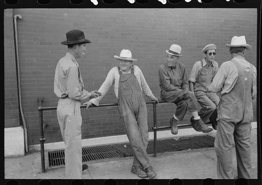Men leaning and sitting on rail, Muskogee, Oklahoma