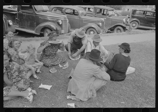 Farm people eating watermelon on lawn in front of courthouse, Tahlequah, Oklahoma