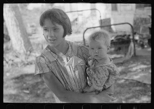 Young girl holding baby brother in her arms, community camp, Oklahoma City Oklahoma