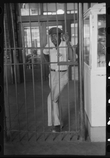Untitled photo, possibly related to: Negro waiting behind barricade at streetcar terminal, Oklahoma City, Oklahoma