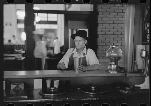 Man drinking malted milk at stand in streetcar terminal, Oklahoma City, Oklahoma
