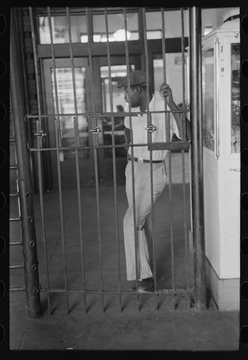 Untitled photo, possibly related to: Negro waiting behind barricade at streetcar terminal, Oklahoma City, Oklahoma