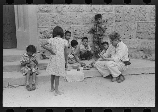 Tourist buying Indian pottery from children at Tesuque pueblo, New Mexico