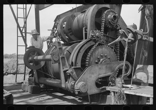 Untitled photo, possibly related to: Cable tool equipment with operator. Oil well near Saint Louis, Oklahoma. This is equipment used in drilling