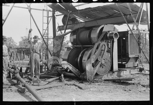 Untitled photo, possibly related to: Examining mud from bottom of hole to determine characterisitcs of stratum through which they are drilling oil. Near Saint Louis, Oklahoma