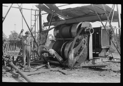 Untitled photo, possibly related to: Examining mud from bottom of hole to determine characterisitcs of stratum through which they are drilling oil. Near Saint Louis, Oklahoma