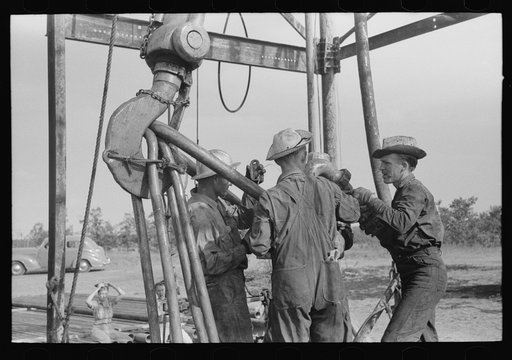 Untitled photo, possibly related to: Oil workers working on lowered traveling block, Seminole oil field, Oklahoma