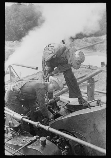 Roughnecks working on engine, Seminole oil field, Oklahoma