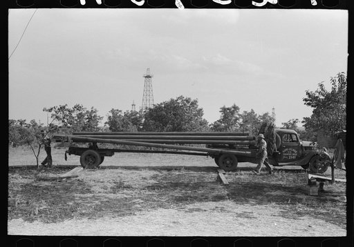 Unloading pipe from truck at oil well, Seminole oil field, Oklahoma