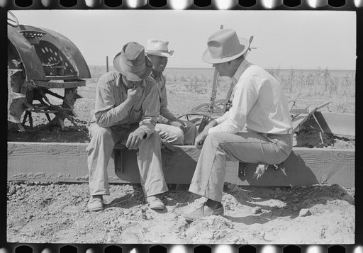 Farm Security Administration supervisor talking with two of the Davidson brothers who own a cooperative well made possible by FSA loan. Gray County, Kansas