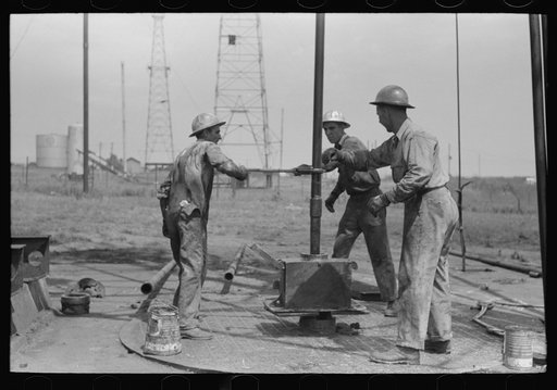 Untitled photo, possibly related to: Roughnecks leaning on the wrench to tighten the joint in the pipe, oil well, Oklahoma City, Oklahoma