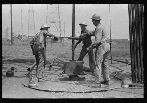 Untitled photo, possibly related to: Roughnecks leaning on the wrench to tighten the joint in the pipe, oil well, Oklahoma City, Oklahoma