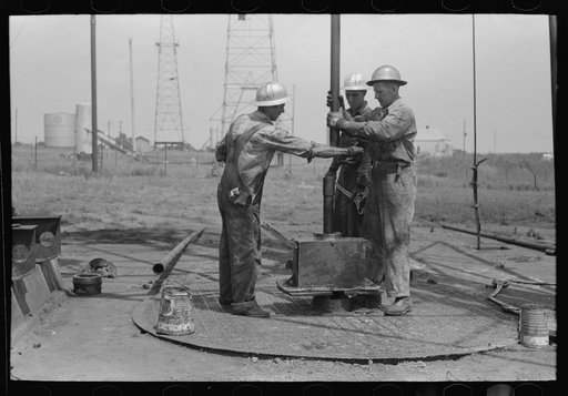 Untitled photo, possibly related to: Roughnecks leaning on the wrench to tighten the joint in the pipe, oil well, Oklahoma City, Oklahoma