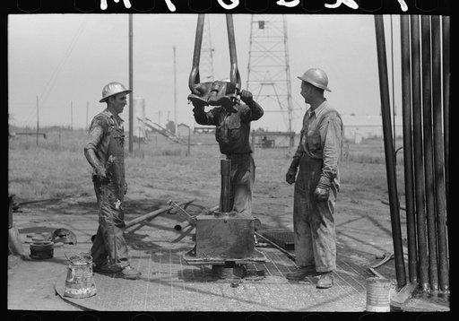 Untitled photo, possibly related to: Roughnecks leaning on the wrench to tighten the joint in the pipe, oil well, Oklahoma City, Oklahoma