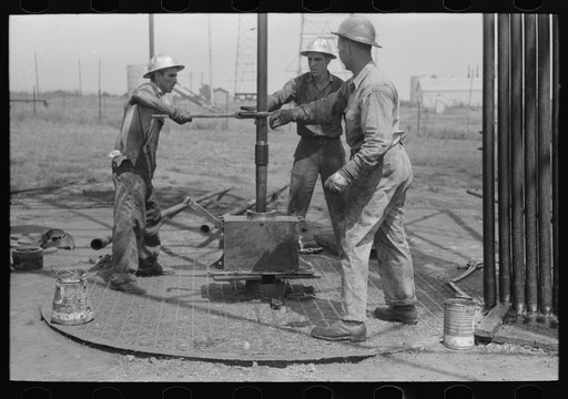 Untitled photo, possibly related to: Roughnecks leaning on the wrench to tighten the joint in the pipe, oil well, Oklahoma City, Oklahoma