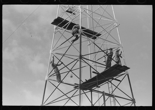 Roustabouts painting an oil well, Seminole oil fields, Oklahoma.