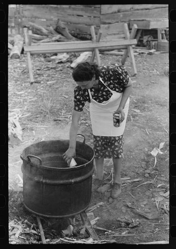 Adding lye to grease in soap making, Spanish-American FSA (Farm Security Administration) client, Taos County, New Mexico