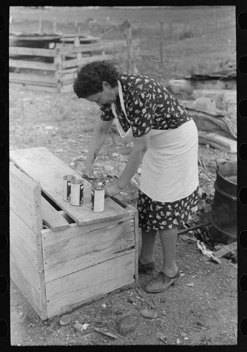 Opening cans of lye to use in making soap, FSA (Farm Security Administration) client, Taos County, New Mexico