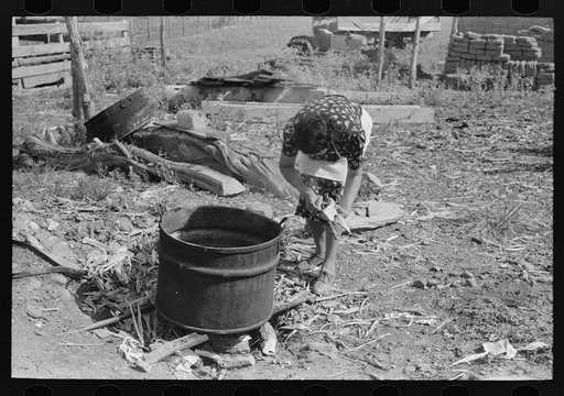 Spanish-American FSA (Farm Security Administration) client building fire under soap kettle, Taos County, New Mexico