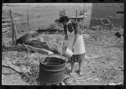 Spanish-American FSA (Farm Security Administration) client adding water to soap kettle, Taos County, New Mexico