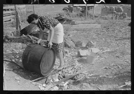 Spanish-American FSA (Farm Security Administration) client rinsing soap kettle before using, Taos County, New Mexico