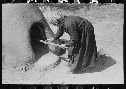Untitled photo, possibly related to: Spanish-American woman putting loaf of bread into oven, Taos County, New Mexico