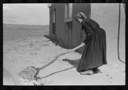 Untitled photo, possibly related to: Sweeping hot coals from outdoor earthen oven after it has been heated to proper temperature to bake bread, Taos County, New Mexico