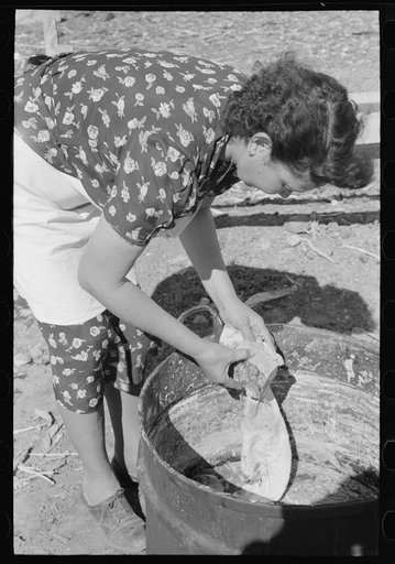 Spanish-American FSA (Farm Security Administration) client wiping homemade soap to remove surface dirt, Taos County, New Mexico