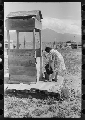 Untitled photo, possibly related to: Daughter of Spanish-American farm family drawing water at the well, Taos County, New Mexico