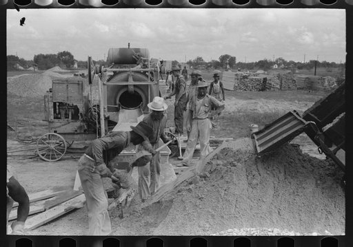 Activity around concrete mixer at migrant camp under construction at Sinton, Texas