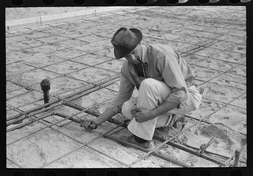 Fitting water pipe at migrant camp under construction at Sinton, Texas