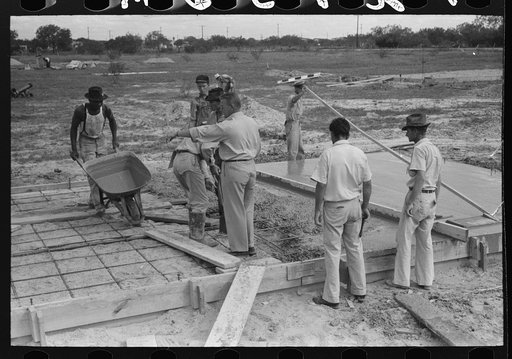 Untitled photo, possibly related to: Smoothing concrete floor at migrant camp under construction at Sinton, Texas