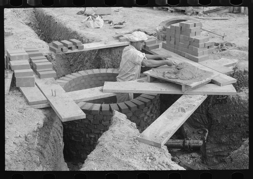 Untitled photo, possibly related to: Laying bricks in construction of manhole at migrant camp at Sinton, Texas