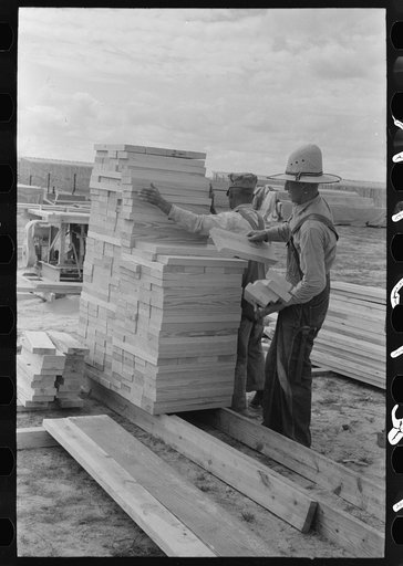Piling precut blocks of wood at migrant camp under construction at Sinton, Texas