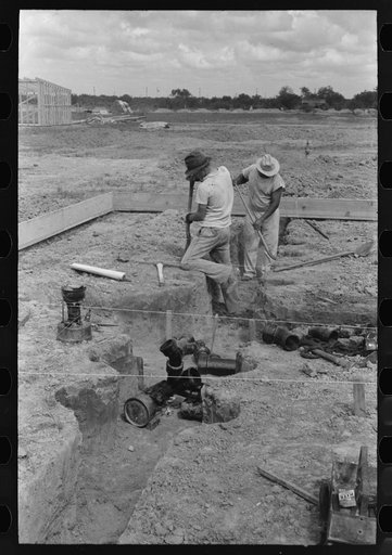 Untitled photo, possibly related to: Soldering a joint of cast iron sewer pipe at migrant camp under construction at Sinton, Texas