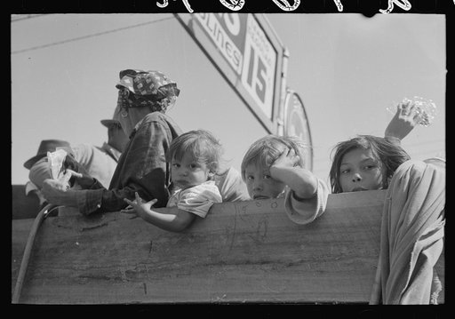 Untitled photo, possibly related to: Mexican woman and children looking over side of truck which is taking them to their homes in the Rio Grande Valley from Mississippi where they have been picking cotton. Filling station, Neches, Texas