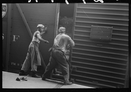 Untitled photo, possibly related to: Unloading bale of cotton from freight car at cotton compress, Houston, Texas